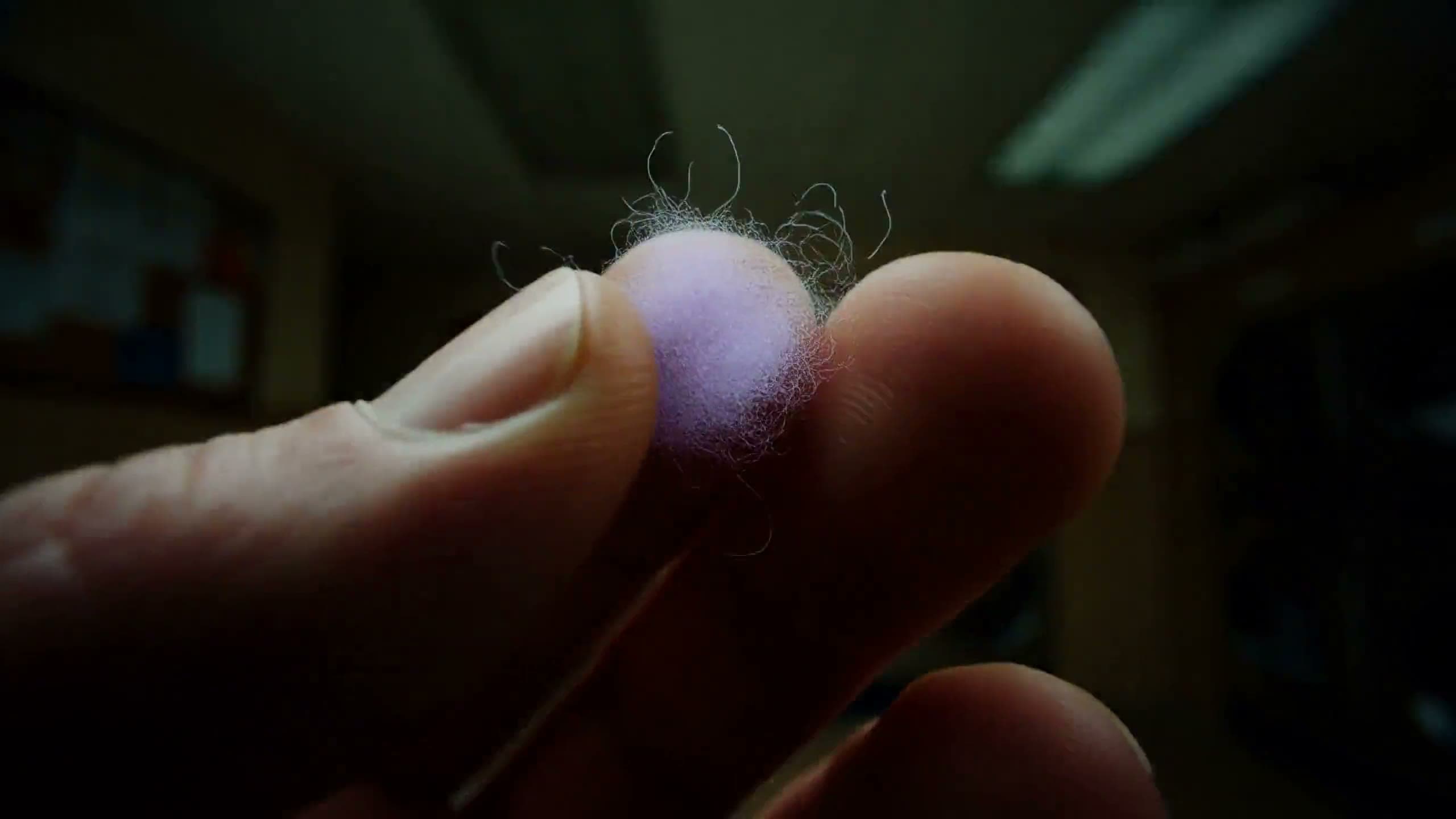 A hand at a laundromat washer as the room turns into neon line art